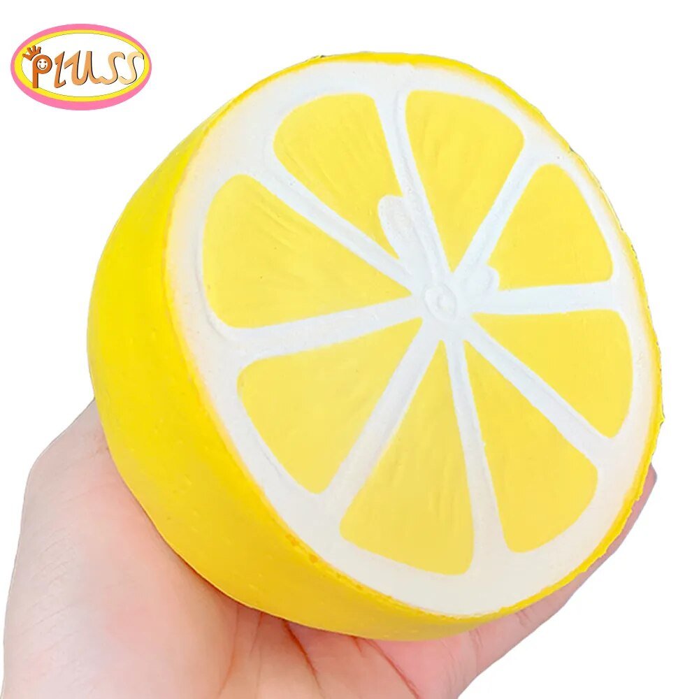 Yellow lemon-shaped squishy toy held in a hand with a visible brand logo.