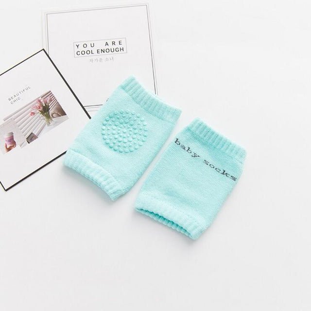 Pair of light blue baby socks on a white surface with text in the background.