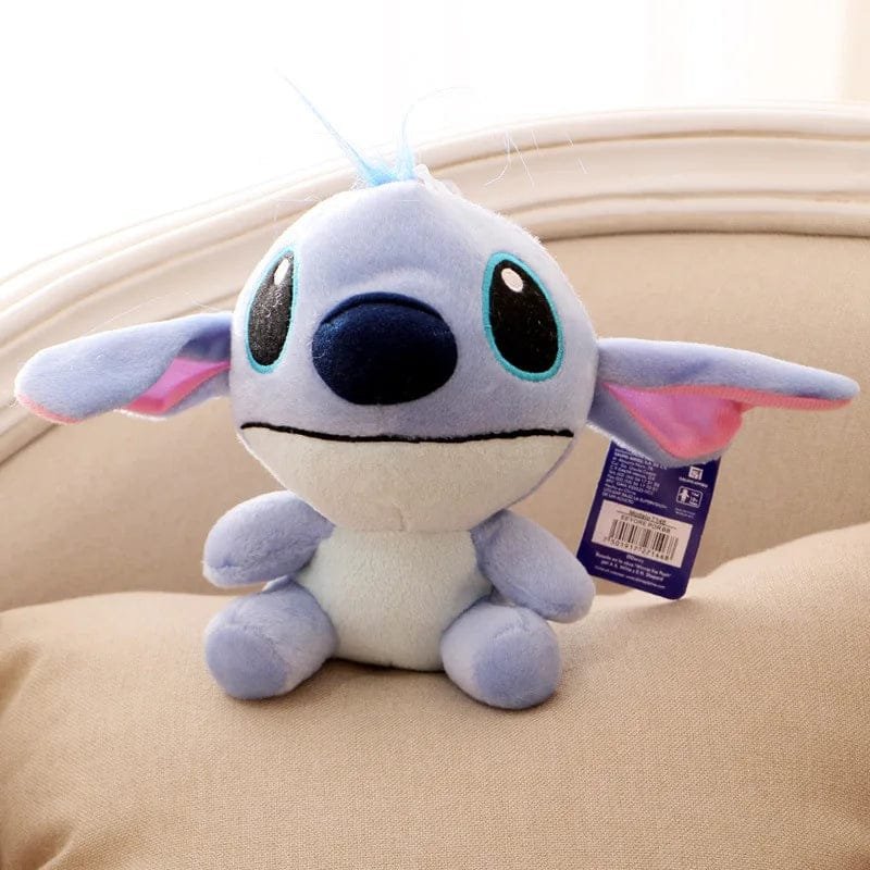 Plush toy resembling a character with a blue face and pink inner ears on a beige surface.