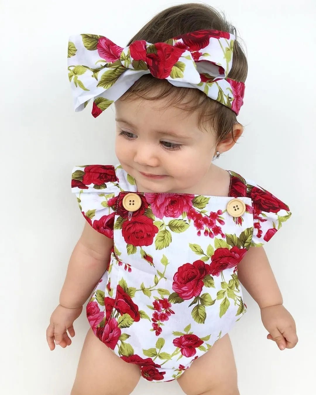 Baby wearing a floral romper and headband