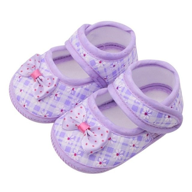 Pair of purple baby shoes with bows