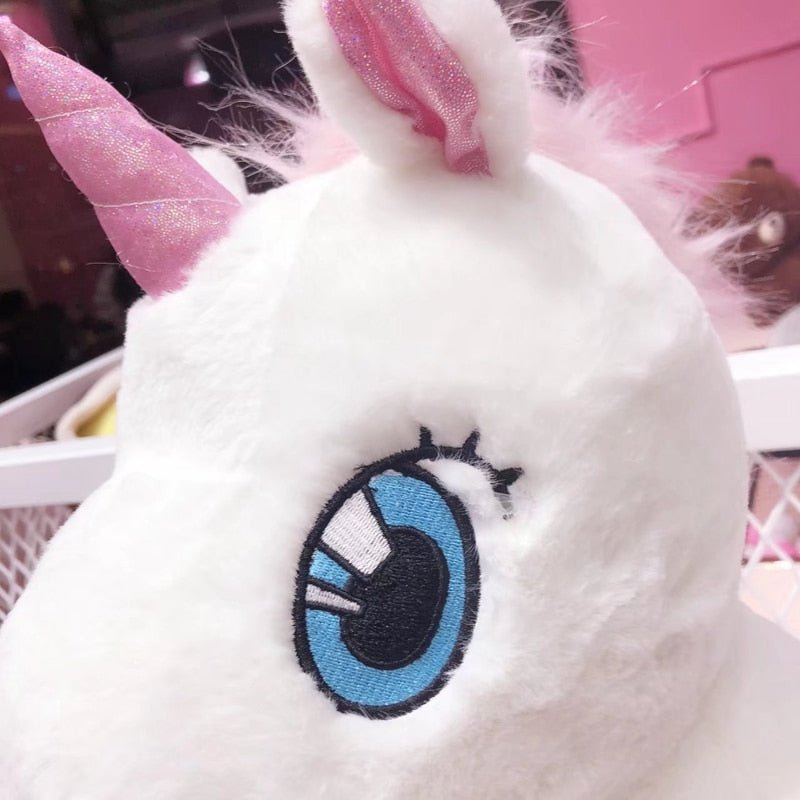 Close-up of a plush toy with pink horns and a blue eye patch.