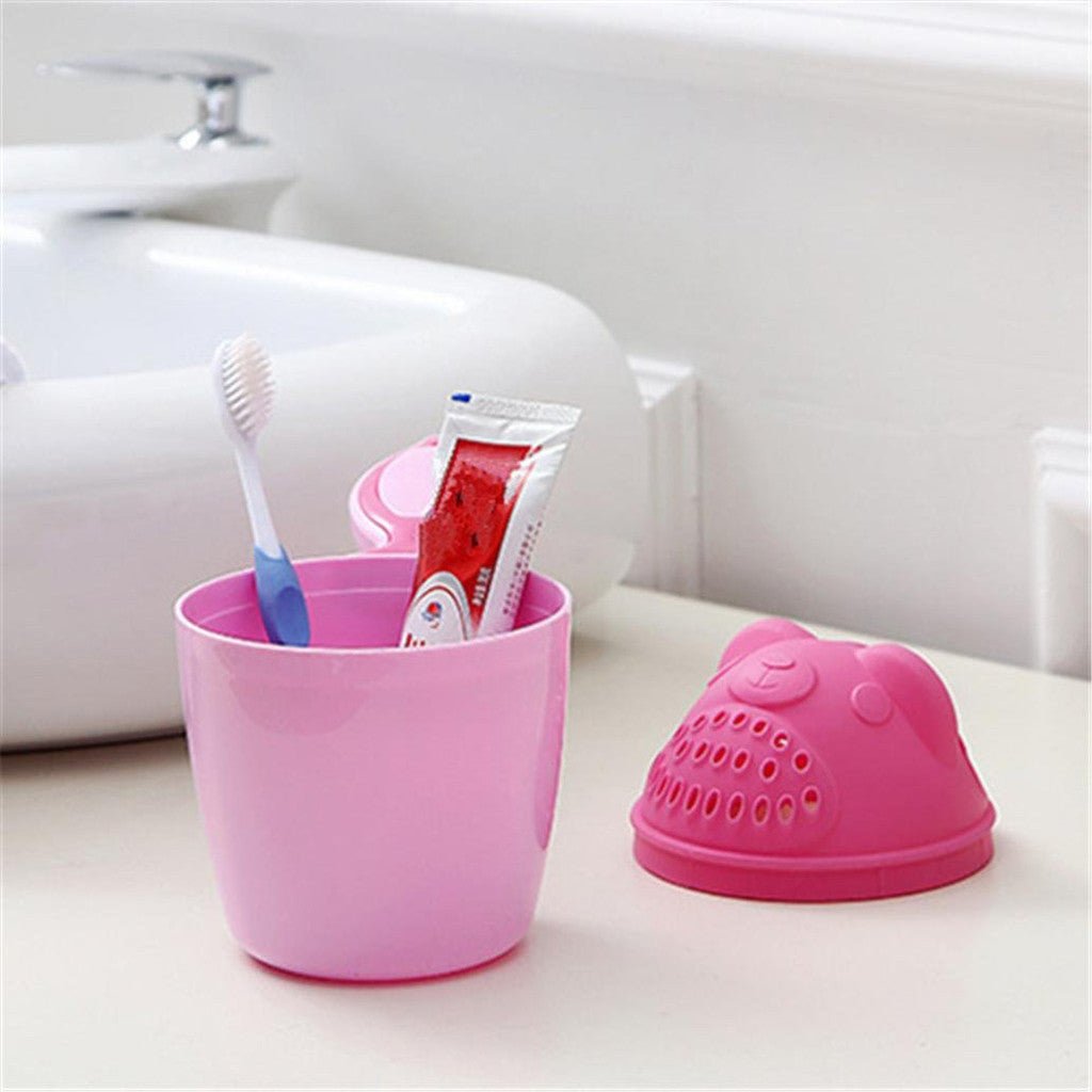 Pink toothbrush holder with toothbrush and toothpaste.