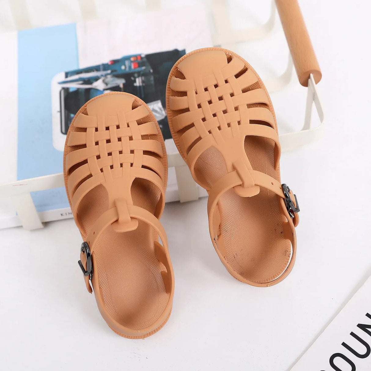 Pair of tan sandals on a white surface