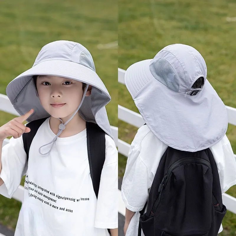 Child wearing a white bucket hat with a chin strap in an outdoor setting