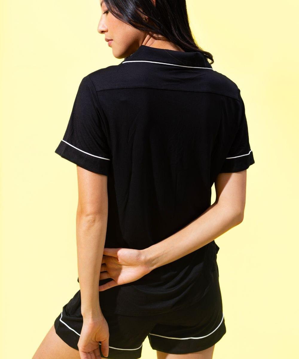 Person wearing a black polo shirt and shorts set