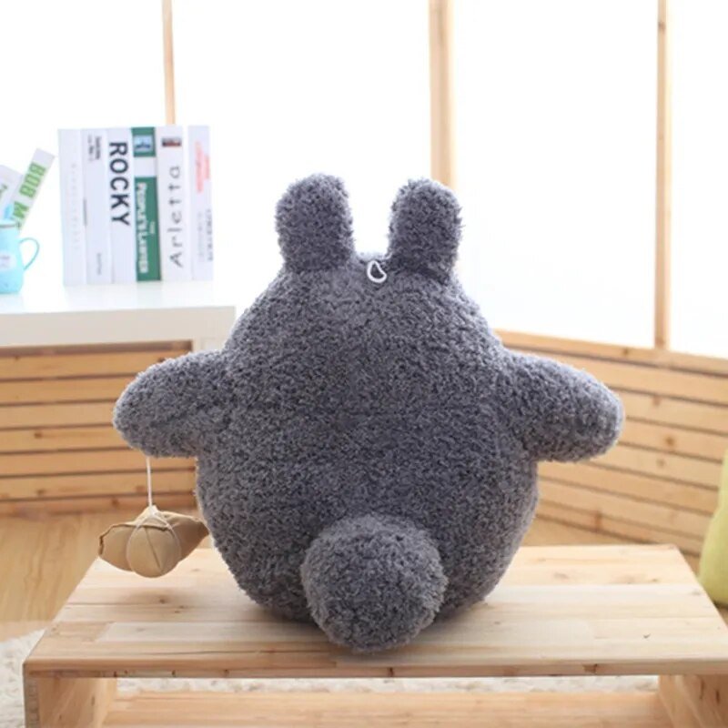 Plush toy resembling a character with large ears on a wooden surface.