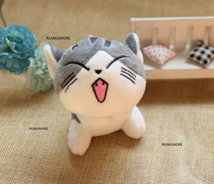 Plush toy cat with open mouth on a textured surface, brand 'RUIMUMORE' visible