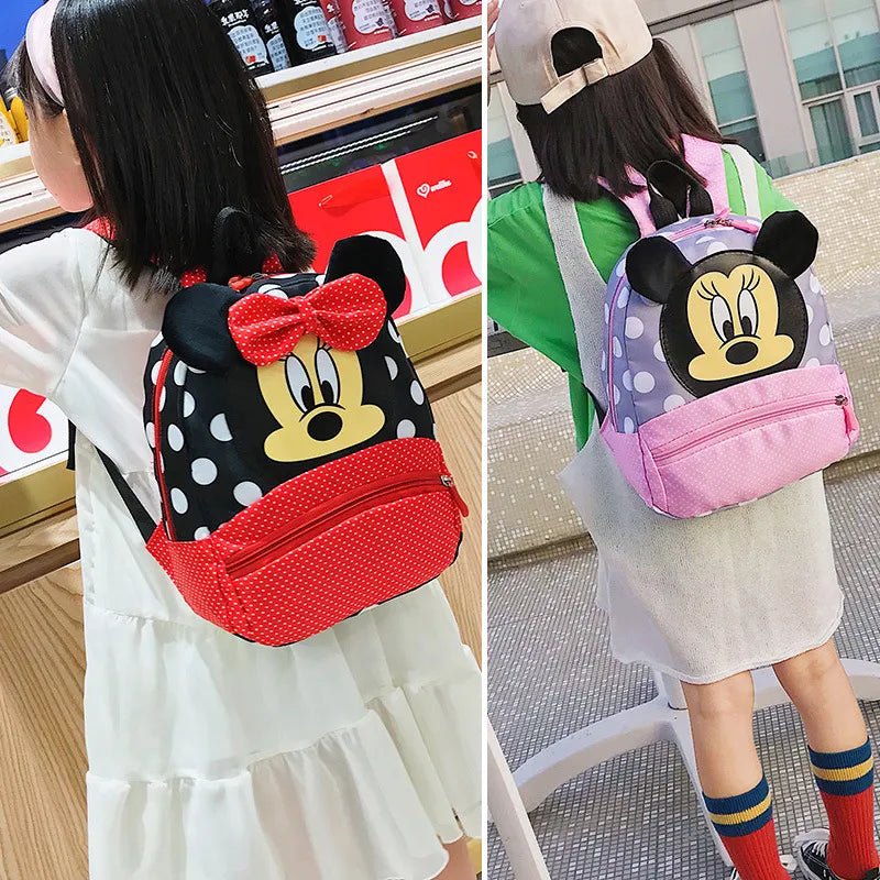 Two children wearing backpacks with cartoon designs, one black and red, the other pink and white.