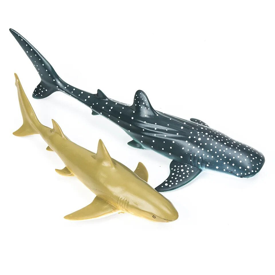 Two shark models, one gold and one gray with white spots, on a white background.