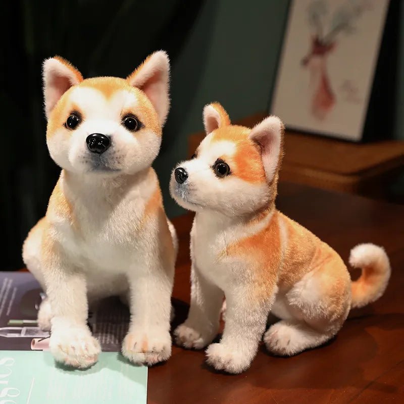 Two plush Shiba Inu dogs on a wooden surface with a dark background