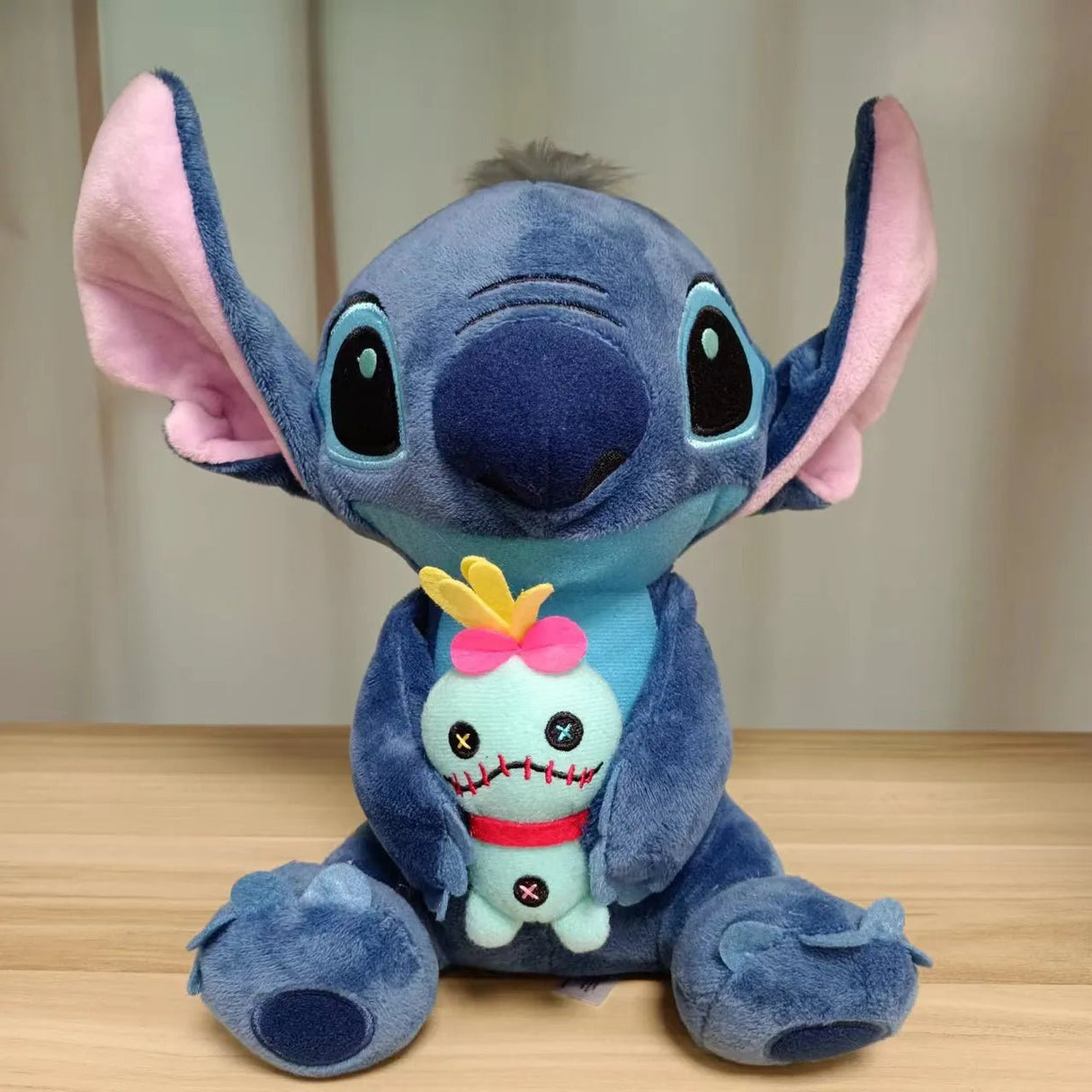 Plush toy resembling a character with a smaller plush toy inside on a wooden surface.