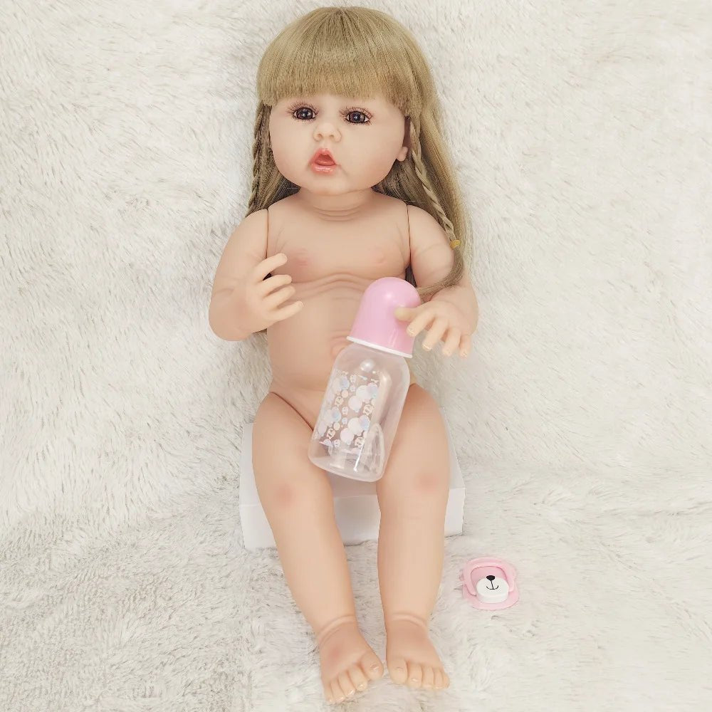 Baby doll with a bottle on a soft white surface