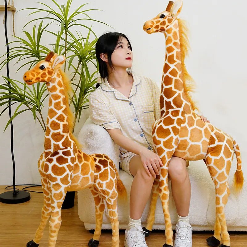 A woman sitting on a couch with two large plush giraffes.