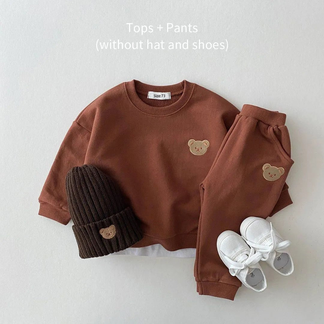 Brown children's outfit with teddy bear design, including a top, pants, hat, and shoes