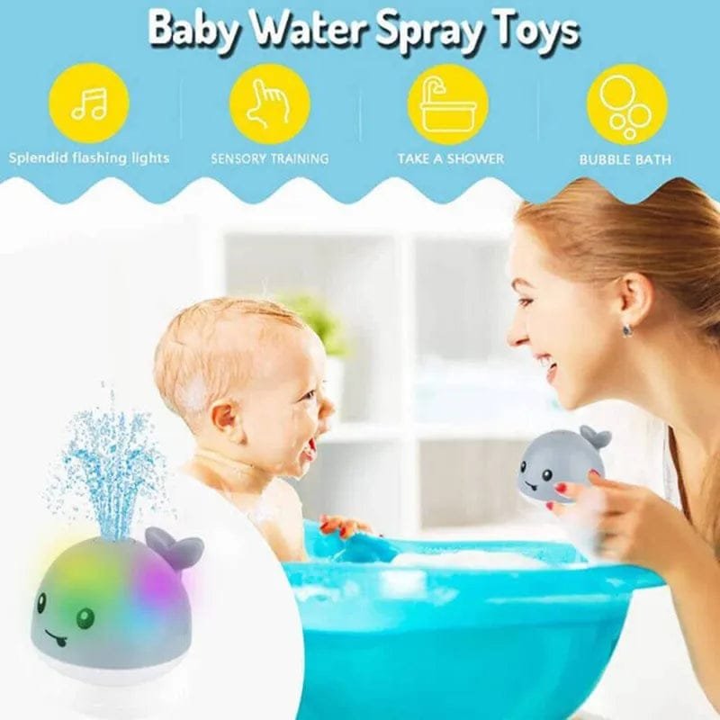 Baby playing with water spray toys in a bathtub, with a woman beside them.