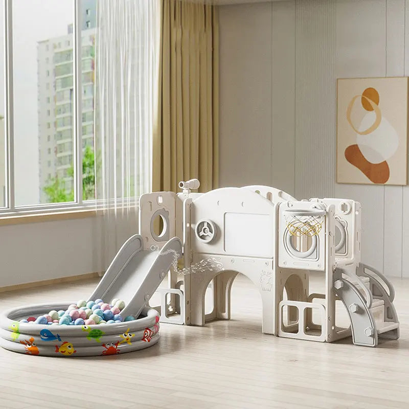 Children's playset with slide and ball pit in a room with large window