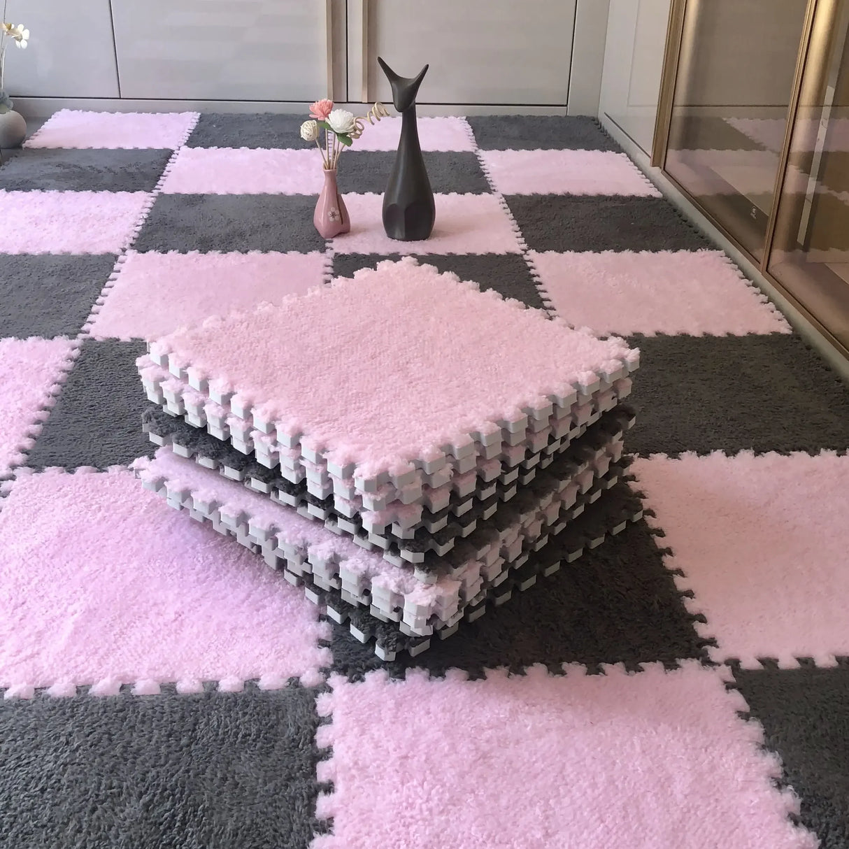 Pink and gray checkered foam mats on a floor with decorative vases.