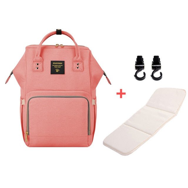 Pink backpack with a white mat and black hooks.