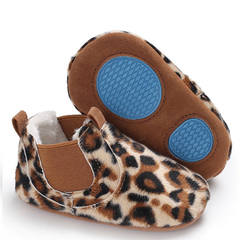 Pair of baby shoes with leopard print and blue soles.