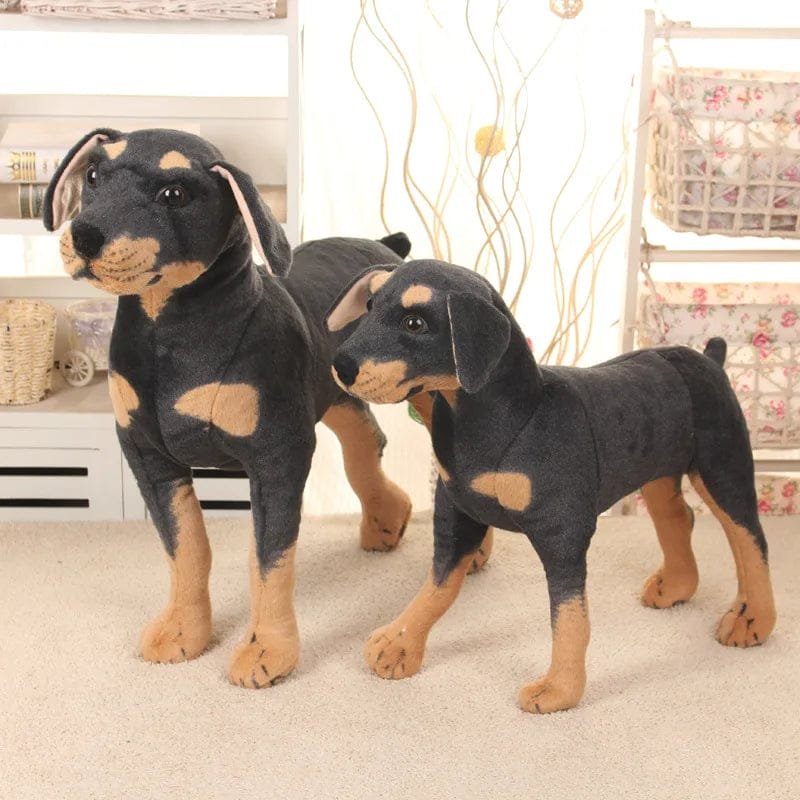 Two Doberman plush toys standing on a carpeted floor.
