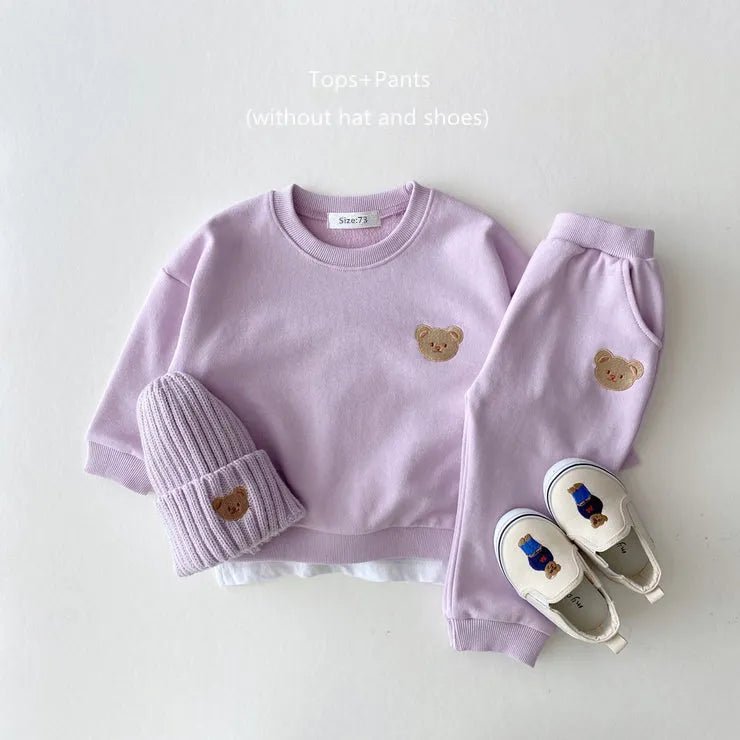 Children's outfit set with lavender top, pants, hat, and shoes featuring bear designs