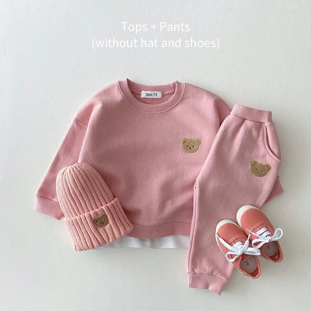 Pink children's outfit with bear designs.