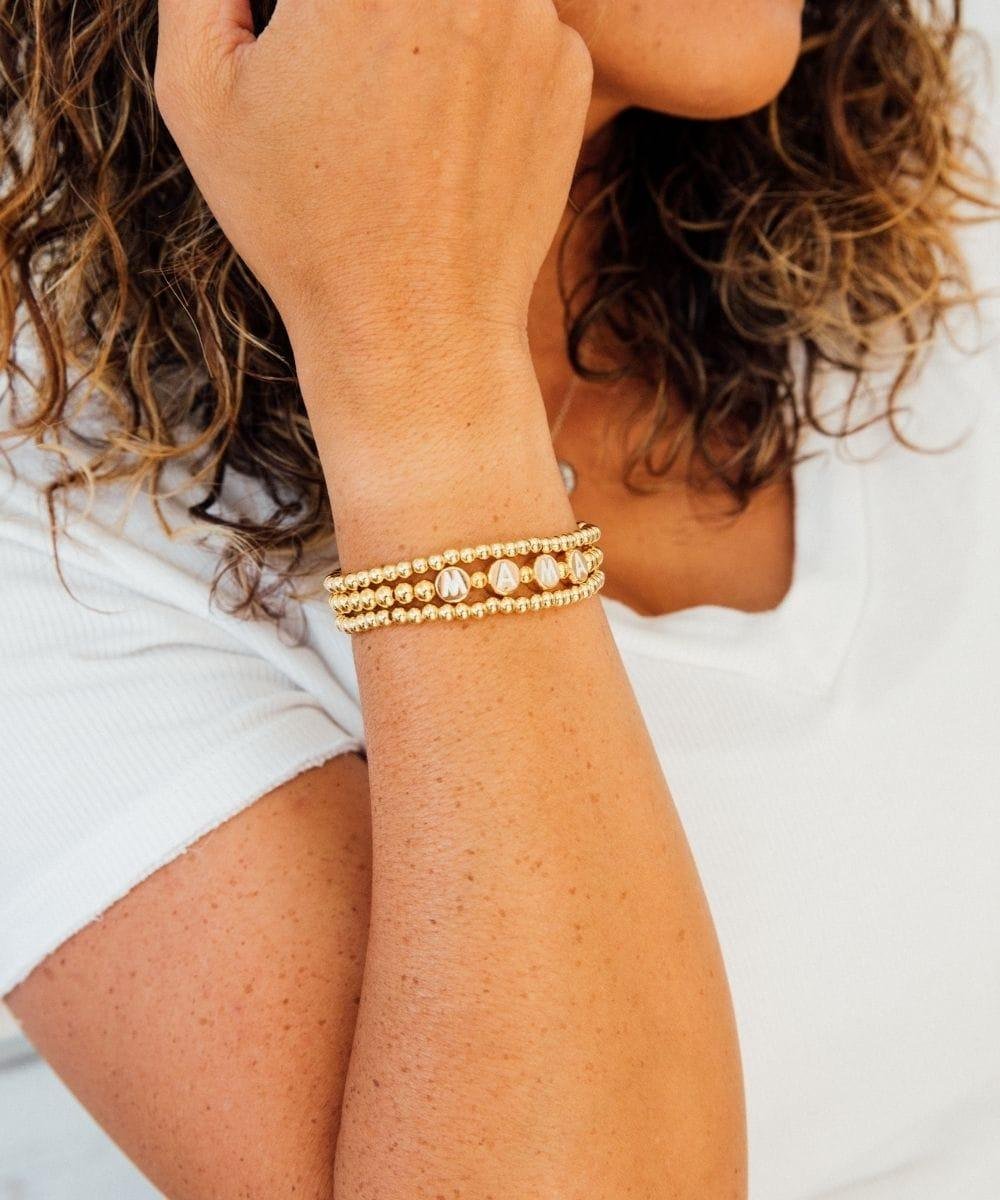 Close-up of a person's arm wearing gold bracelets.