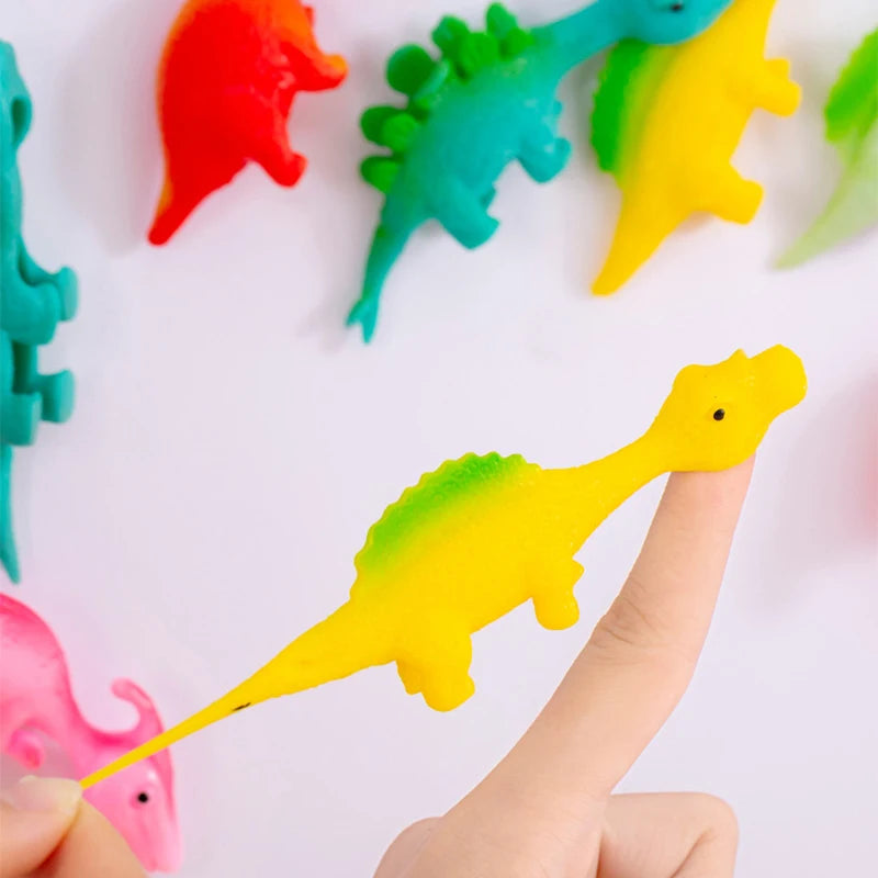 Colorful dinosaur toys on a white background with a hand holding a yellow toy.