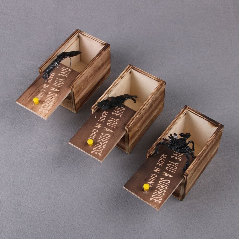 Three wooden boxes with black figurines and 'Give you a surprise' tags.