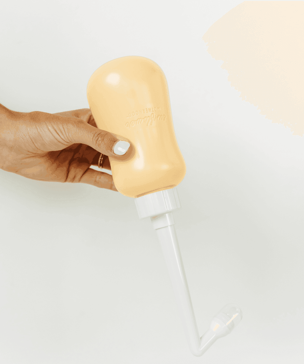 Hand holding a beige bottle with a white cap.