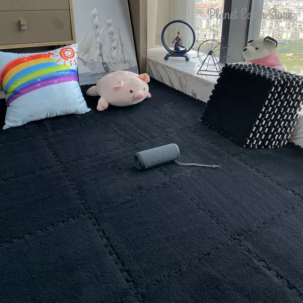 Dark quilted blanket on a bed with a pink plush toy, rainbow pillow, and black textured cube.