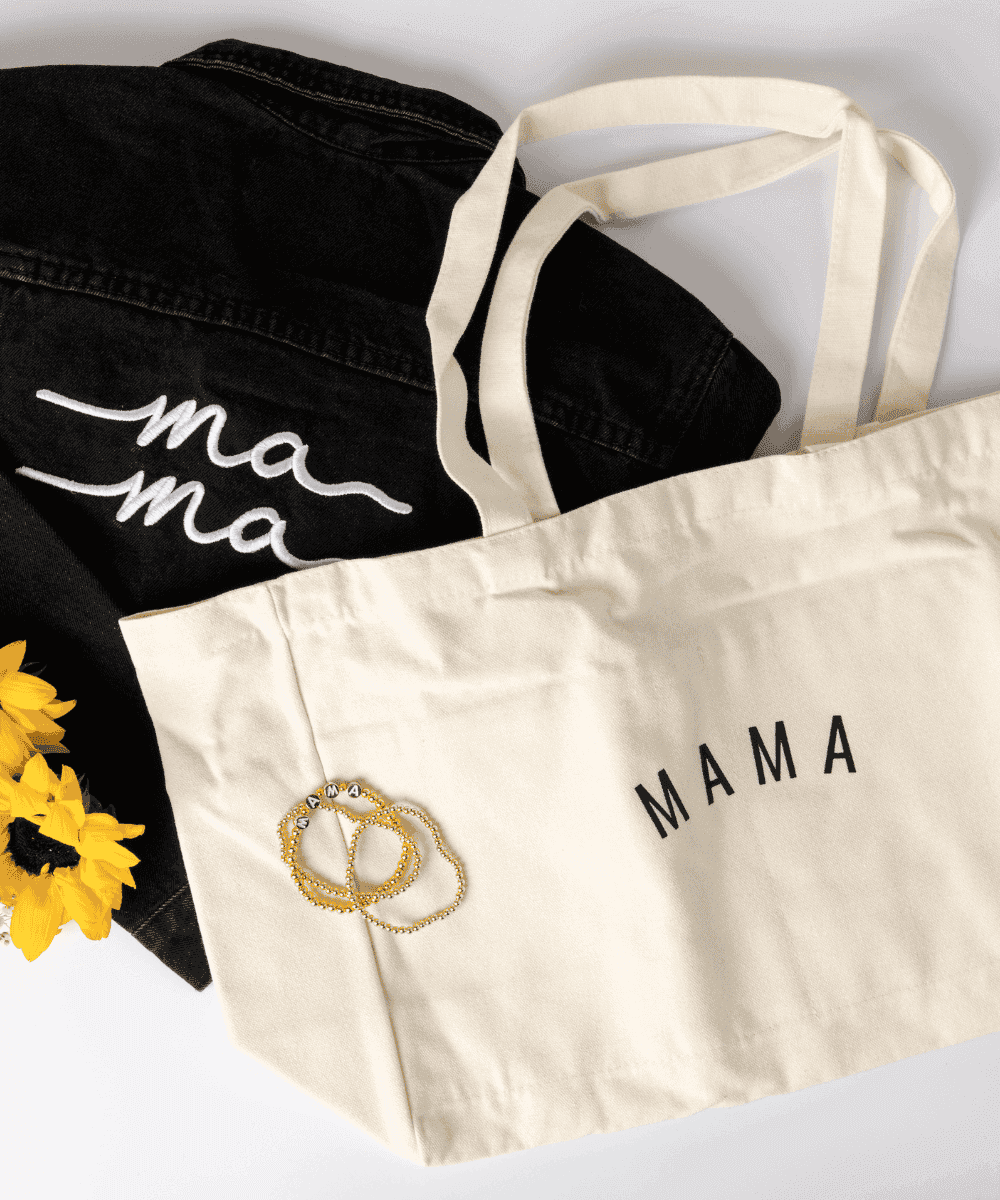 Beige tote bag with 'MAMA' text, black apron with 'ma ma' text, and sunflowers