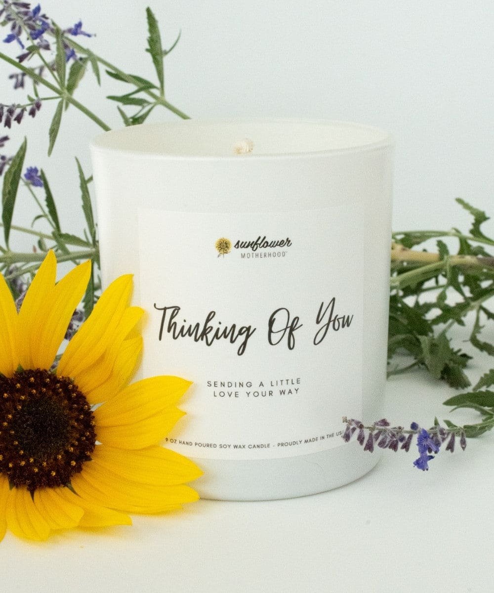 Candle with 'Thinking Of You' text, sunflower, and lavender flowers