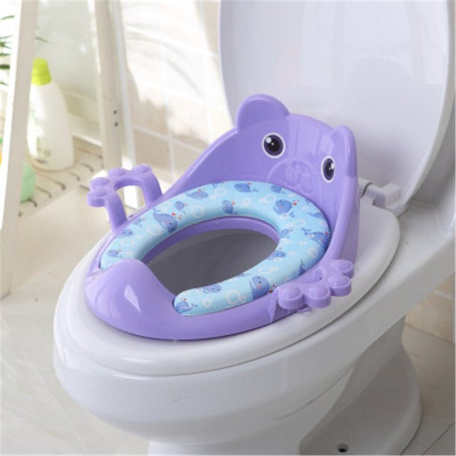 Purple children's toilet seat with cartoon design on a white toilet.