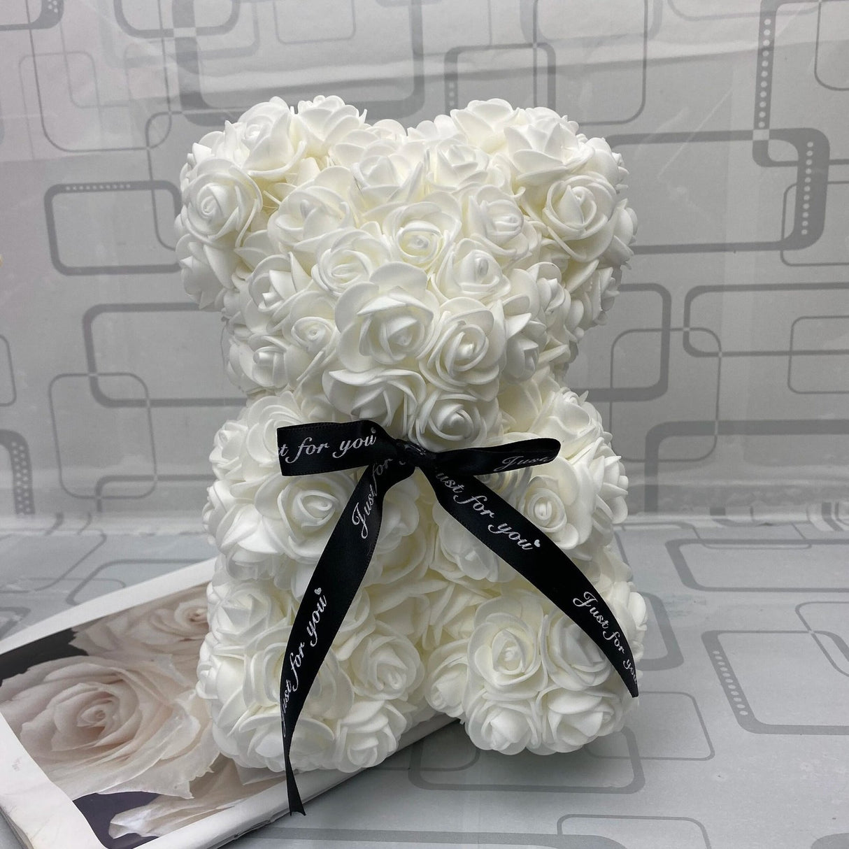 White rose teddy bear with a black ribbon