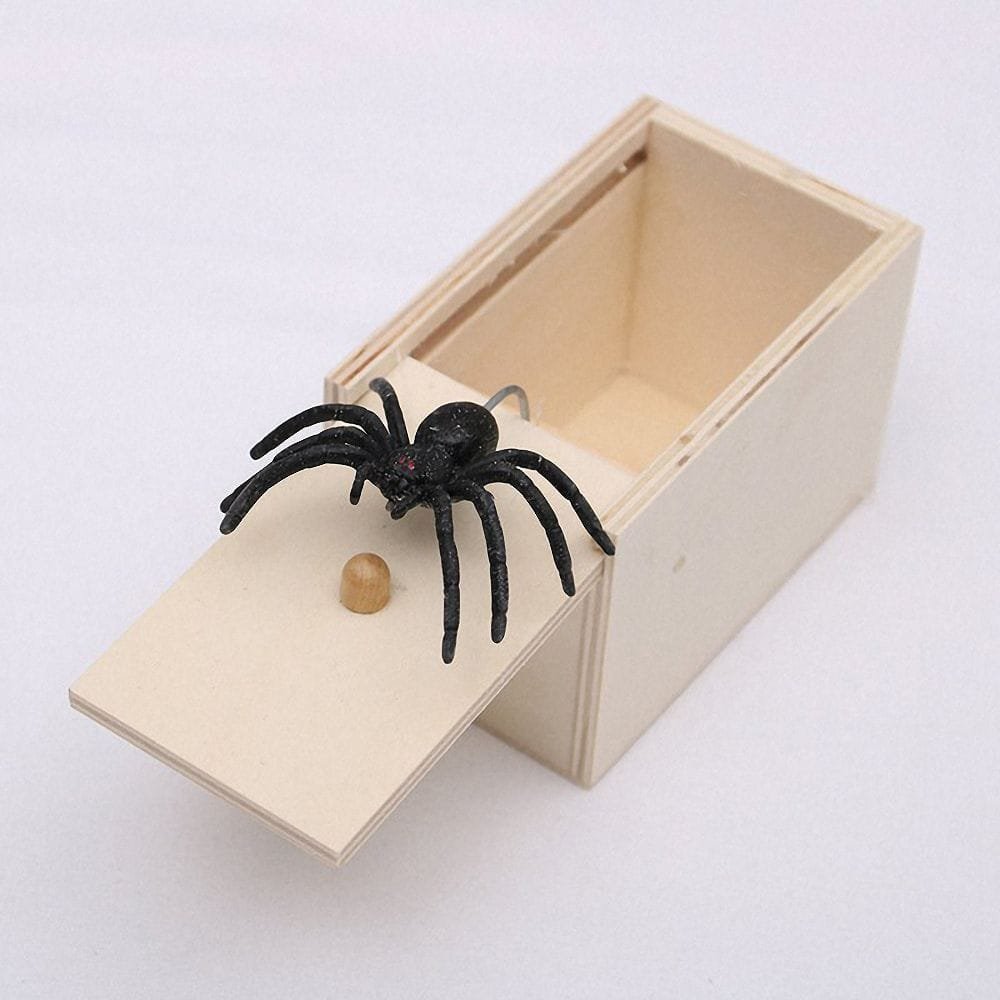 Wooden box with a black spider and a small wooden ball.