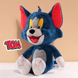 Plush toy of a blue character with red ears on a beige background, featuring the 'Tom' logo.