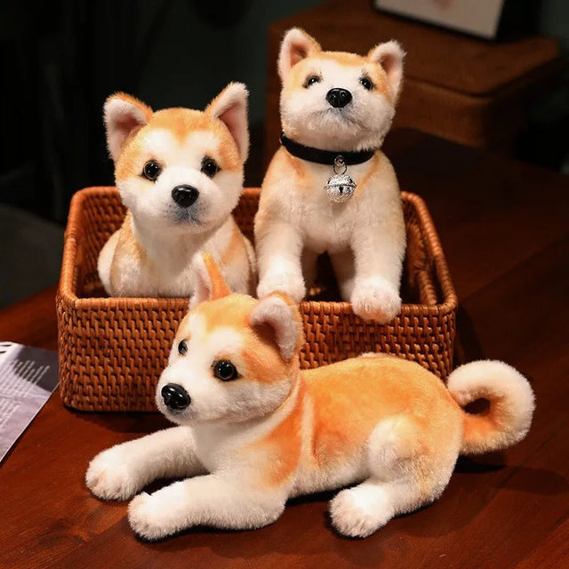 Three plush Shiba Inu dogs in a woven basket on a wooden surface.