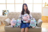 Woman sitting on a couch with colorful unicorn plush toys