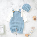 Baby blue knitted romper with matching hat on a light gray surface.