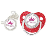 Red pacifier with 'Princess' and crown design, surrounded by rhinestones on a white background.