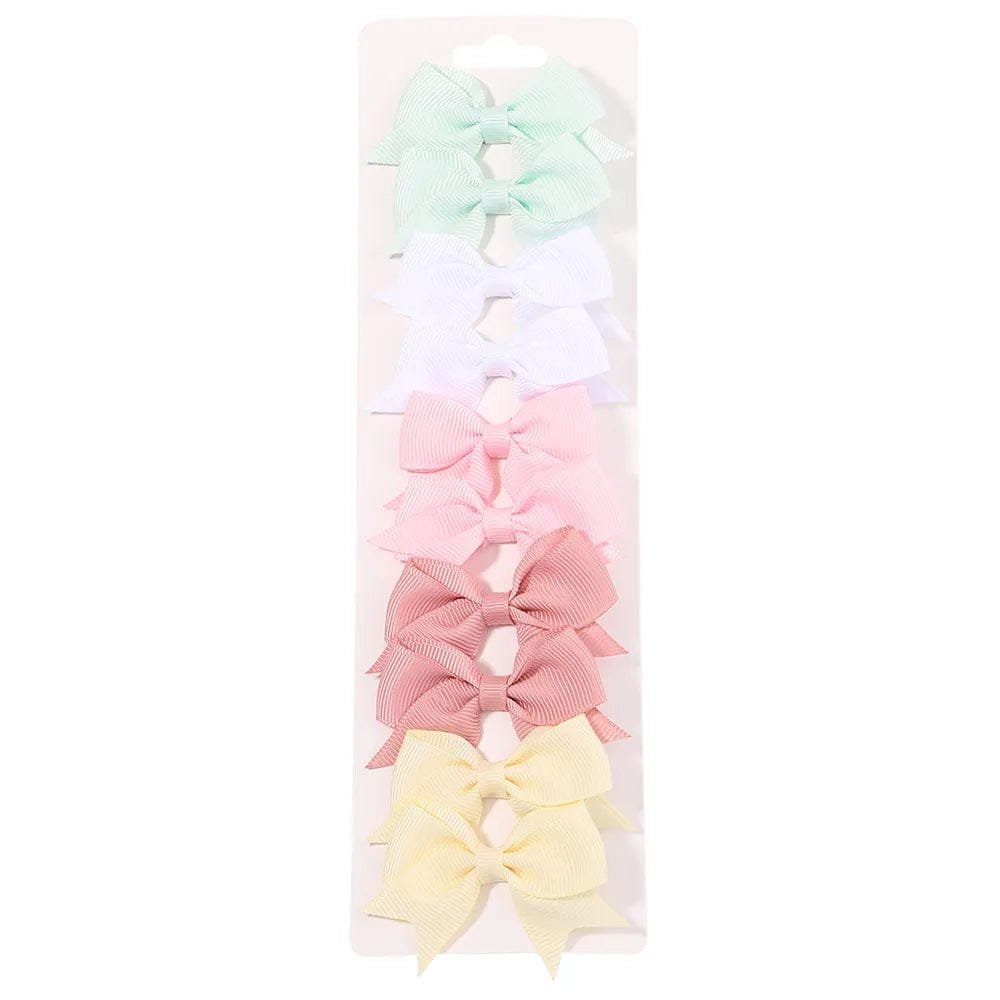 Set of pastel-colored hair bows in a clear packaging on a white background