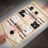 Wooden foosball table game with black and white balls on a light surface