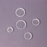 Five clear plastic gears on a purple background