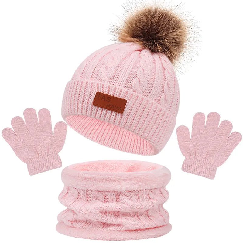 Pink knit beanie with brown pom-pom, matching gloves, and scarf on a white background