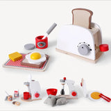 Wooden toy kitchen set with toaster, eggs, and other items on a white background