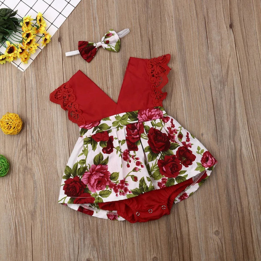 Red and floral baby romper with matching headband on a wooden surface