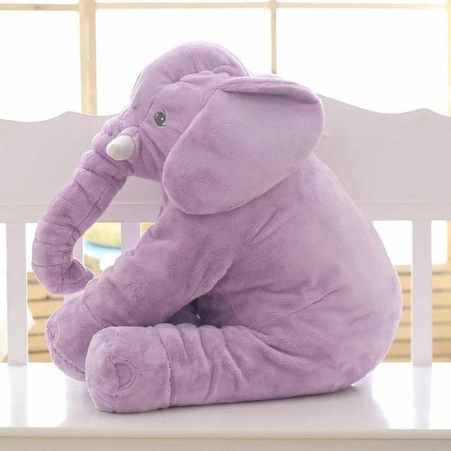 Purple elephant plush toy on a white surface with a blurred background