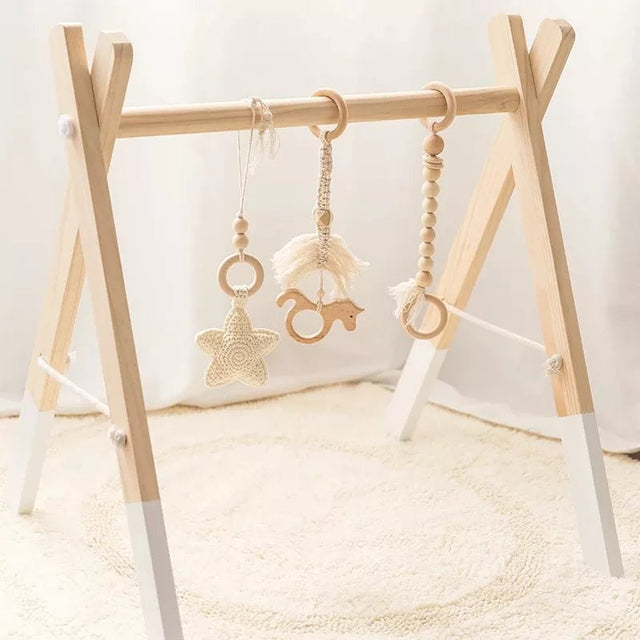 Wooden baby gym with hanging toys.